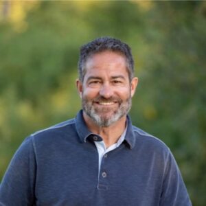 Gregg Rowe, Chief Channel Officer at Globalgig, smiling outdoors in a casual professional portrait.