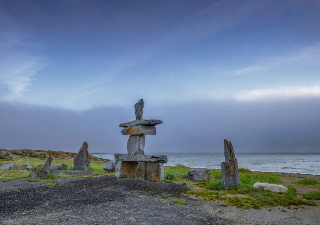 Sunrise over an Inuksuk (Inukshuk) on Hudson Bay at Churchill